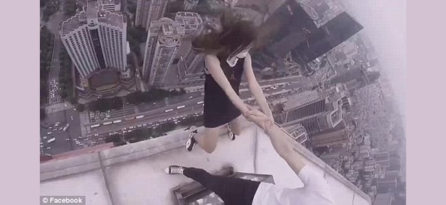 Θα σας κοπεί η ανάσα! Αγόρι κρατάει την κοπέλα του από το χέρι στο κενό...πάνω σε ουρανοξύστη! (Βίντεο)